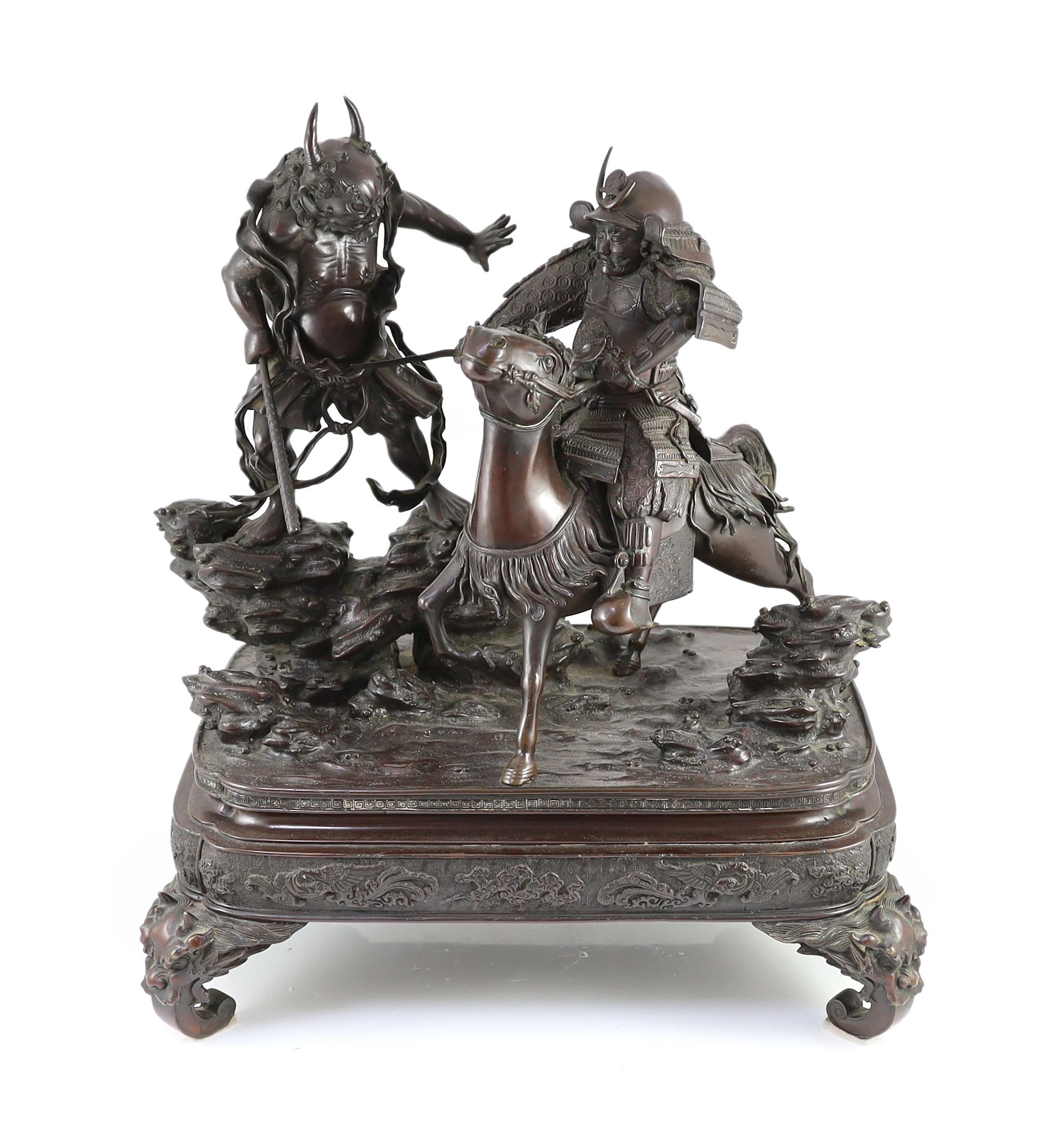 An impressive Japanese bronze group of an oni attacking a Samurai on horseback, Meiji period, 58cm high 49.5cm wide